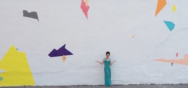 Artist Jennifer Leatherby standing in front of her mural "Untitled Wall #1."